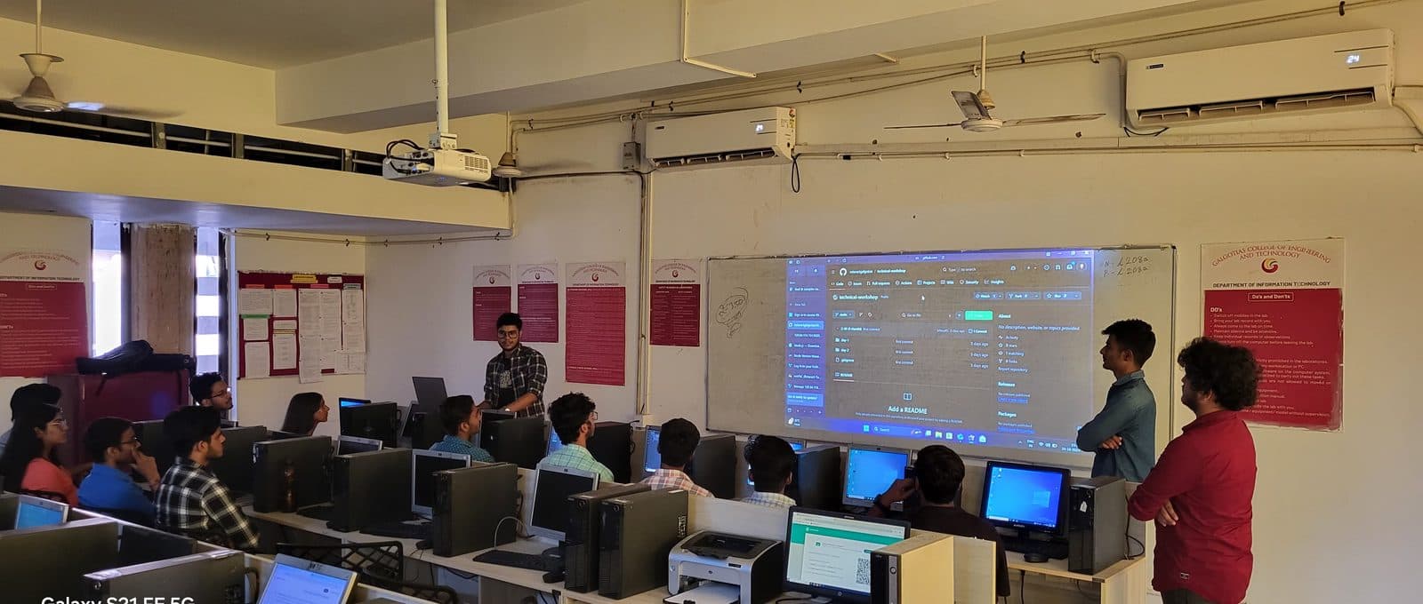 Students in a lab watching a GitHub repository projected on the wall