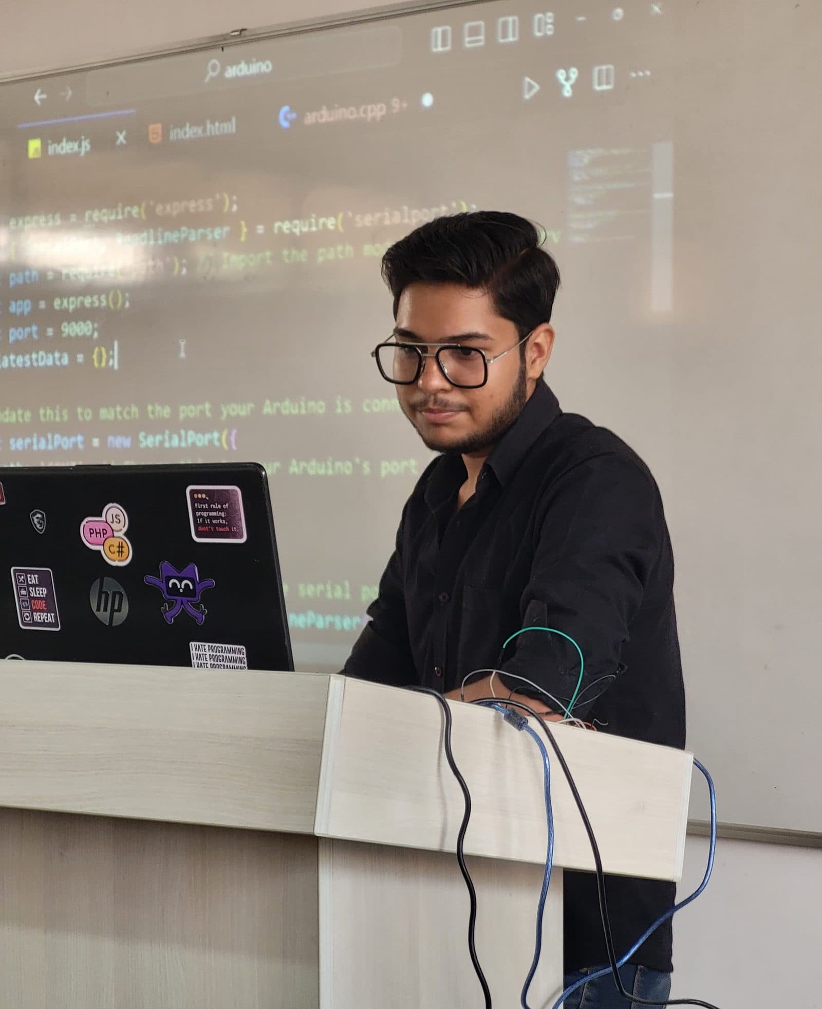 Harshit smiling at the camera from behind the podium during a workshop